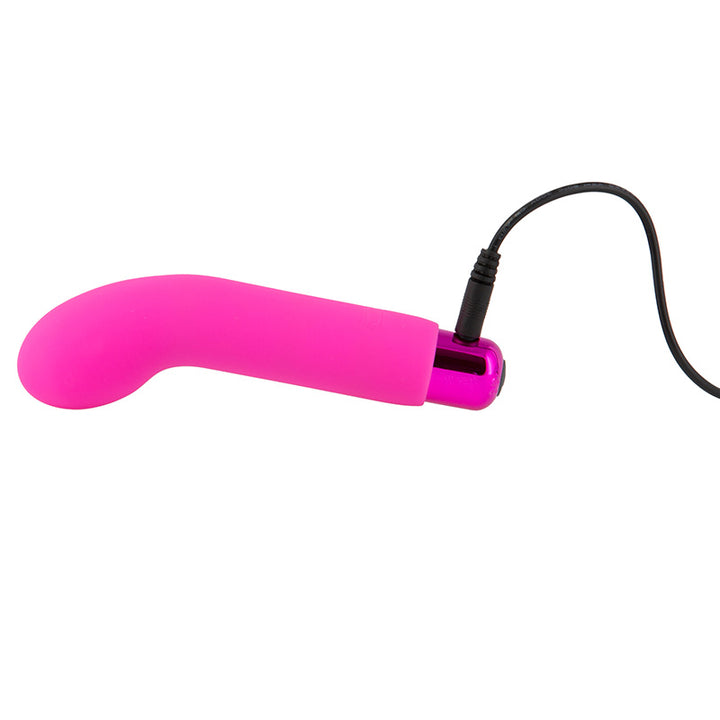 Sara's Spot Mini G-Spot Rechargeable Vibrator in pink shown with charging cable plugged in.