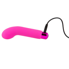 Sara's Spot Mini G-Spot Rechargeable Vibrator in pink shown with charging cable plugged in. 