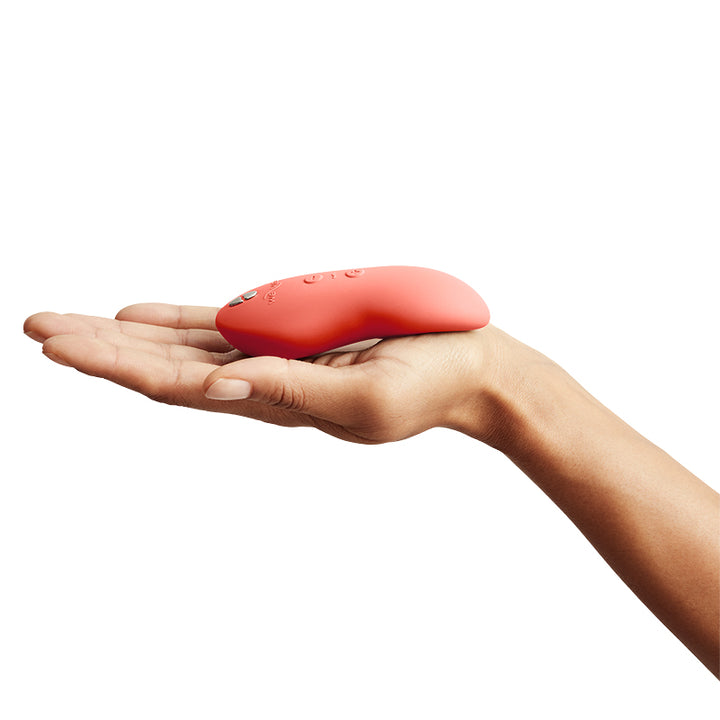 We-Vibe Touch X Magic Multitasker Vibe in coral crave - compact size in palm of hand from the side
